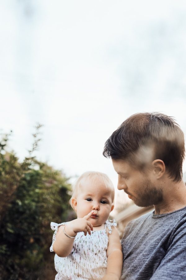 un homme porte son bébé dans les bras après une reconnaissance de paternité