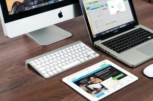Un bureau élégant équipé d'appareils Apple : iMac, MacBook et iPad.
